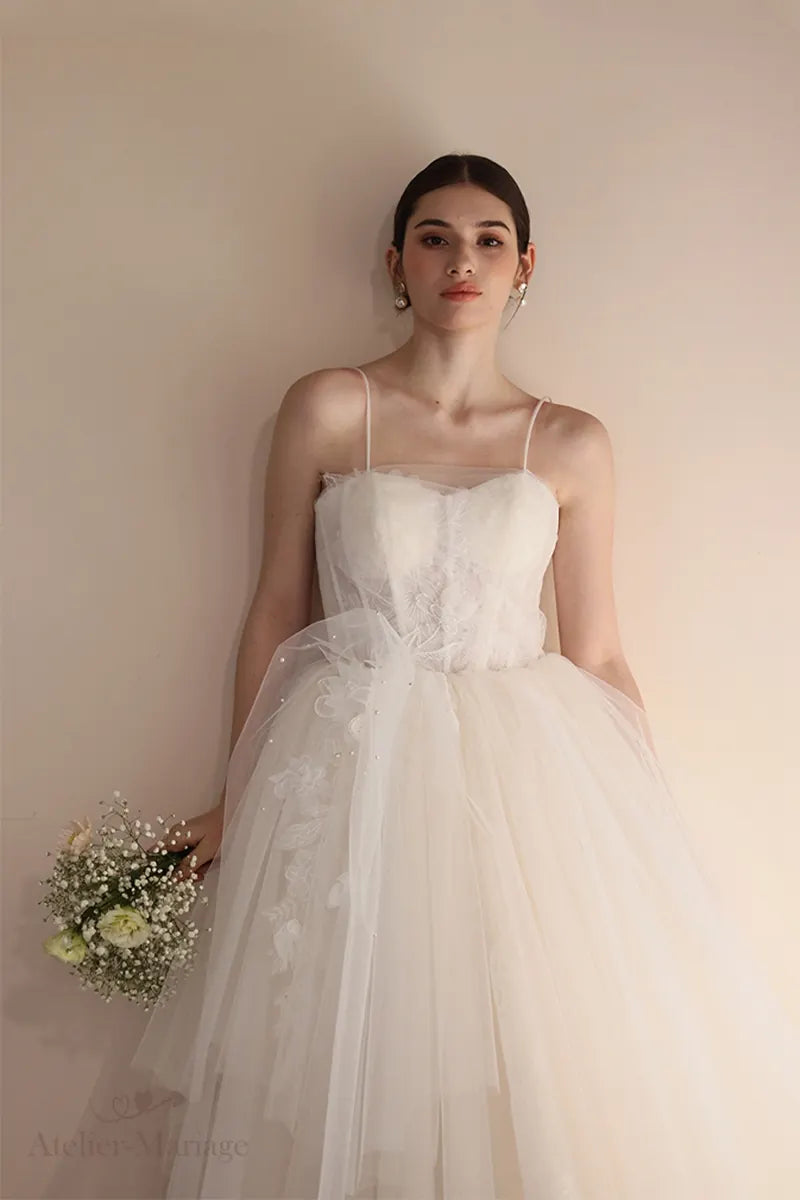 Broderies florales appliquées à la main sur le bustier de la robe asymétrique.