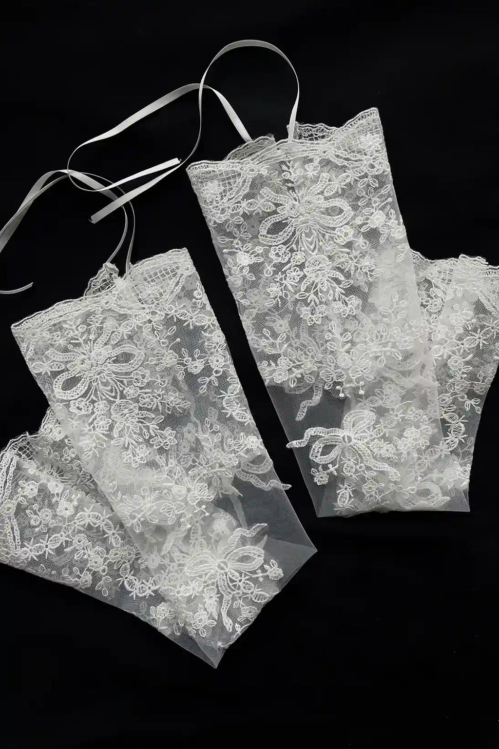 Détail haute couture de la broderie florale et des perles scintillantes sur les manches en tulle.