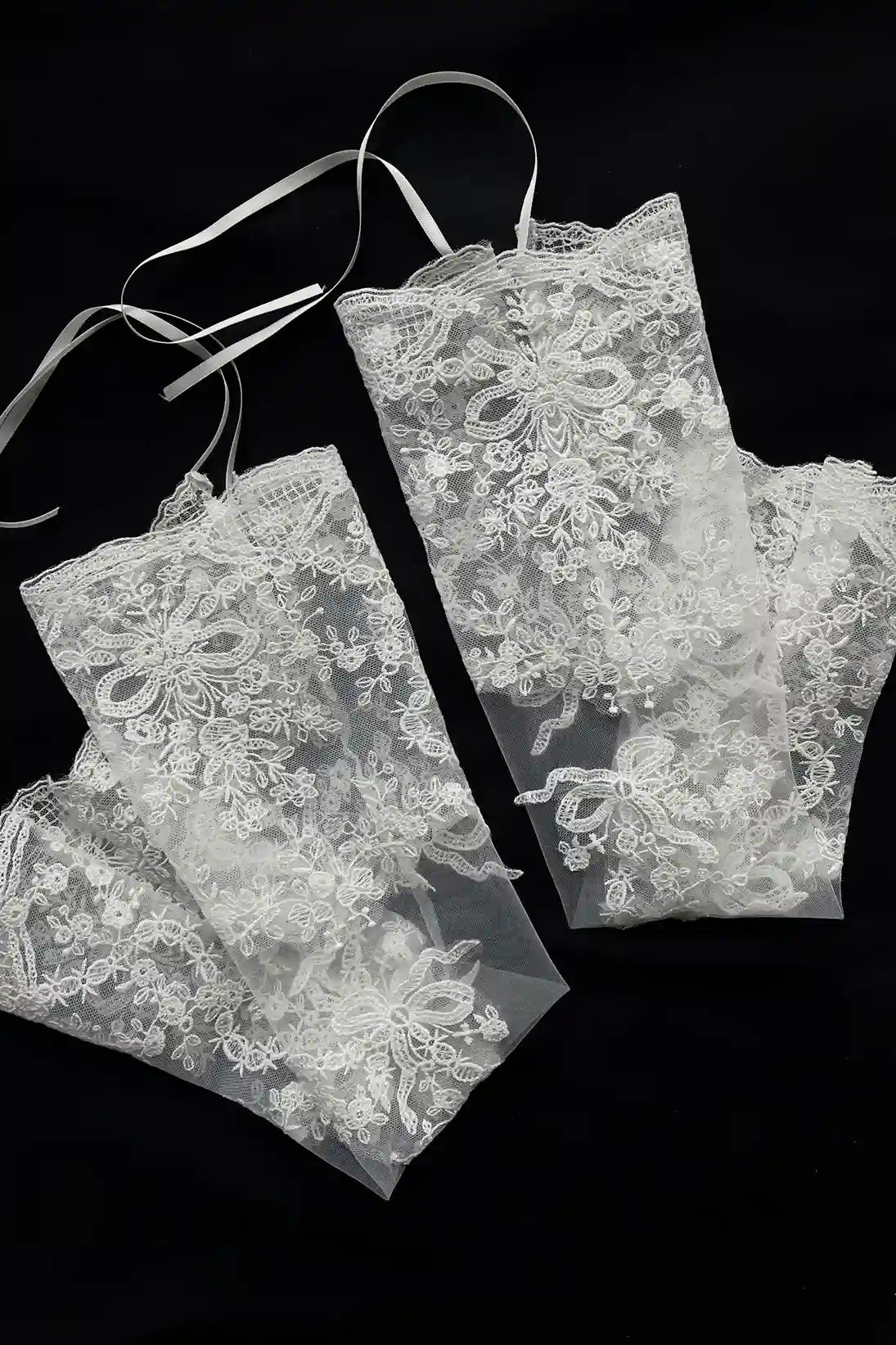Détail haute couture de la broderie florale et des perles scintillantes sur les manches en tulle.