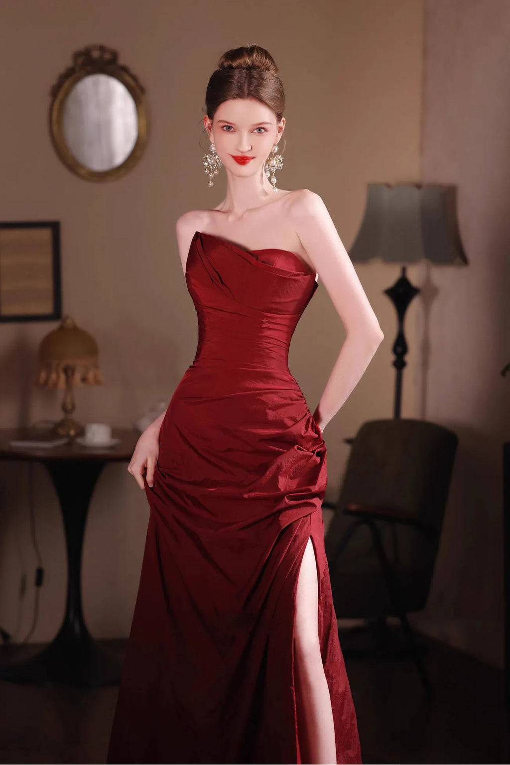Détail du tissu en taffetas à l'aspect froissé naturel et du drapé haute couture sur la robe rouge bordeaux.
