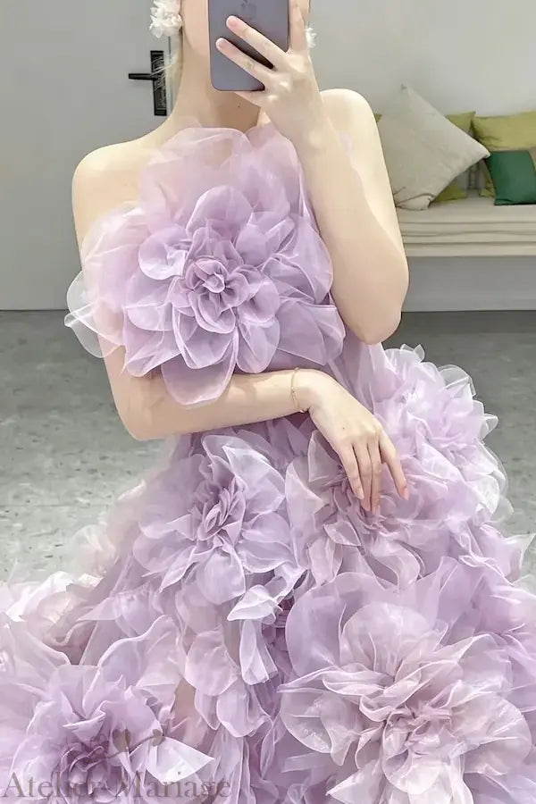 Gros plan sur les fleurs 3D géantes en organza lilas sur le bustier d'une robe de mariée féerique, montrant le relief et la texture artisanale.