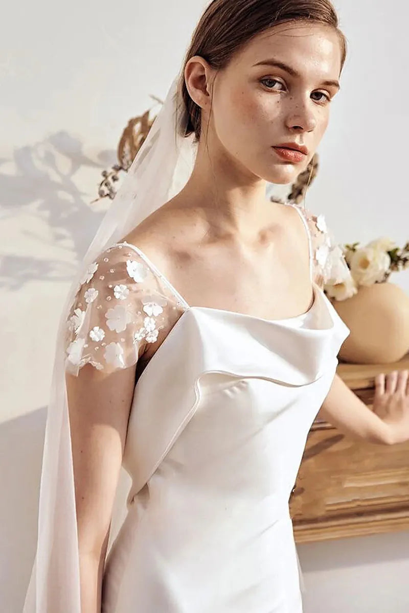 Gros plan sur les manches tombantes ornées de fleurs 3D faites main.