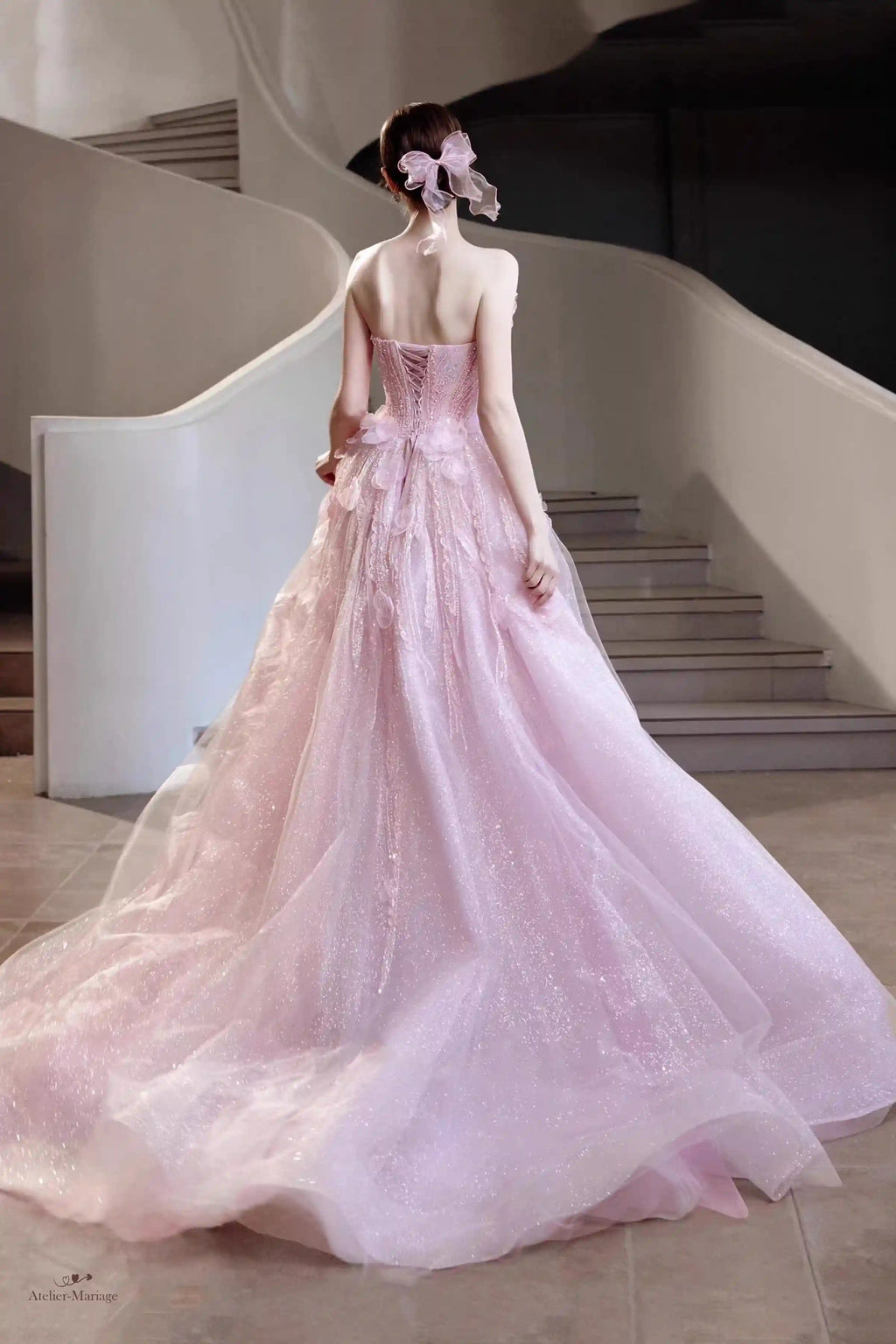 Vue de dos de la robe de mariée blush montrant le laçage corset parfait et le tissu pailleté.