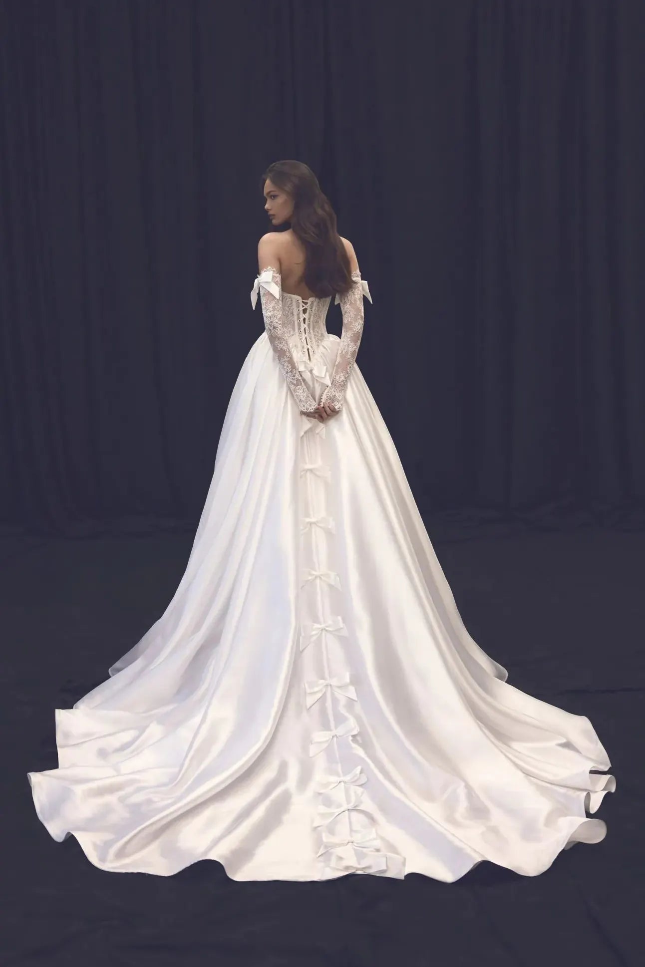 Vue de dos montrant le tombé fluide de la manche en dentelle (53-55cm).