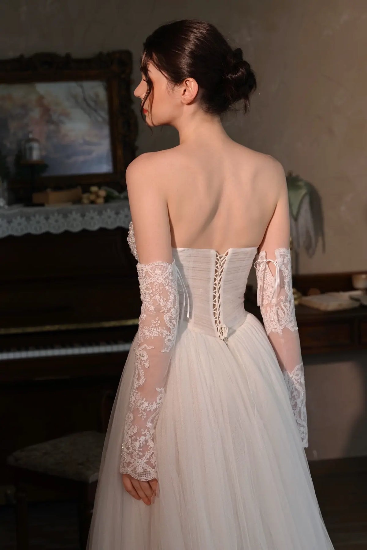 Vue de profil montrant le nœud en ruban fixant les manches amovibles sur le bras de la mariée.