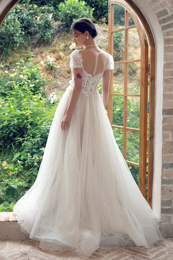 Grand dos nu transparent parsemé de fleurs brodées semblant flotter sur la peau.