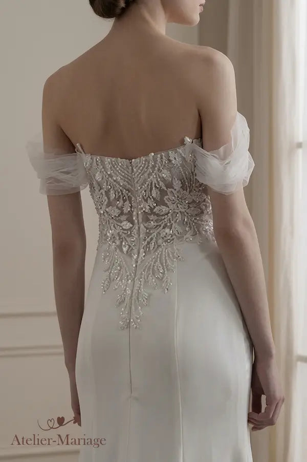 Vue de dos spectaculaire en V ornée de perles et cristaux sur une robe de mariée ajustée.