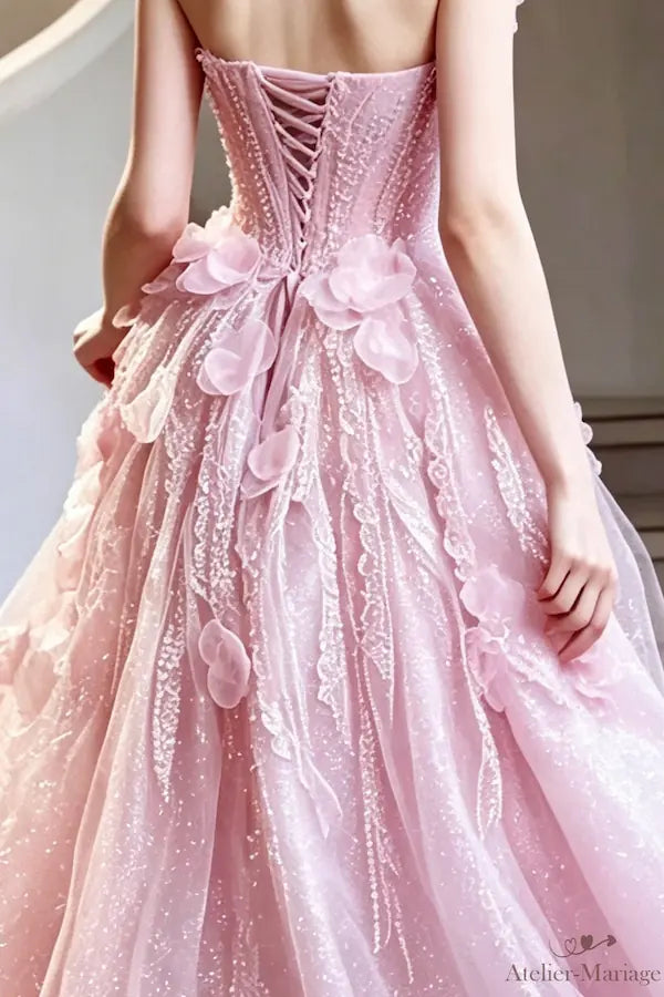 Dos avec laçage corset et fleurs 3D en organza sur une robe de mariée rose blush.
