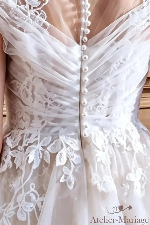 Détails de transparence et boutons perles sur un dos nu élégant en tulle.