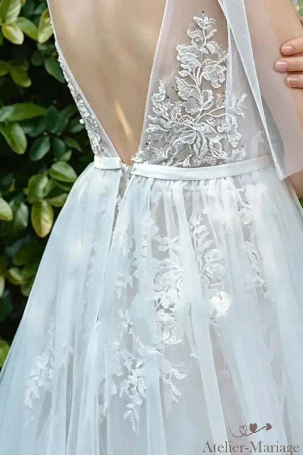 Détail du mouvement des manches cape en tulle fluide, idéal pour un mariage extérieur.