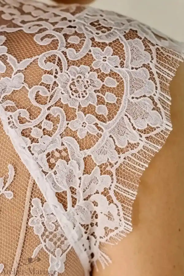 Détails de la dentelle effet tatouage sur l'épaule, artisanat traditionnel de l'atelier.