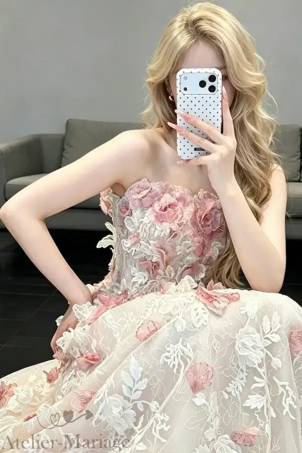 Photo réelle d'un essayage de la robe de mariée blush aux fleurs 3D, montrant le rendu naturel du bustier et des broderies sur une cliente.