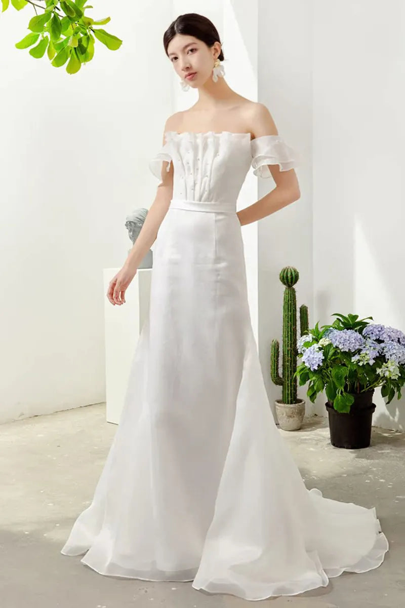 Femme debout portant une robe de mariée chic et simple bohème