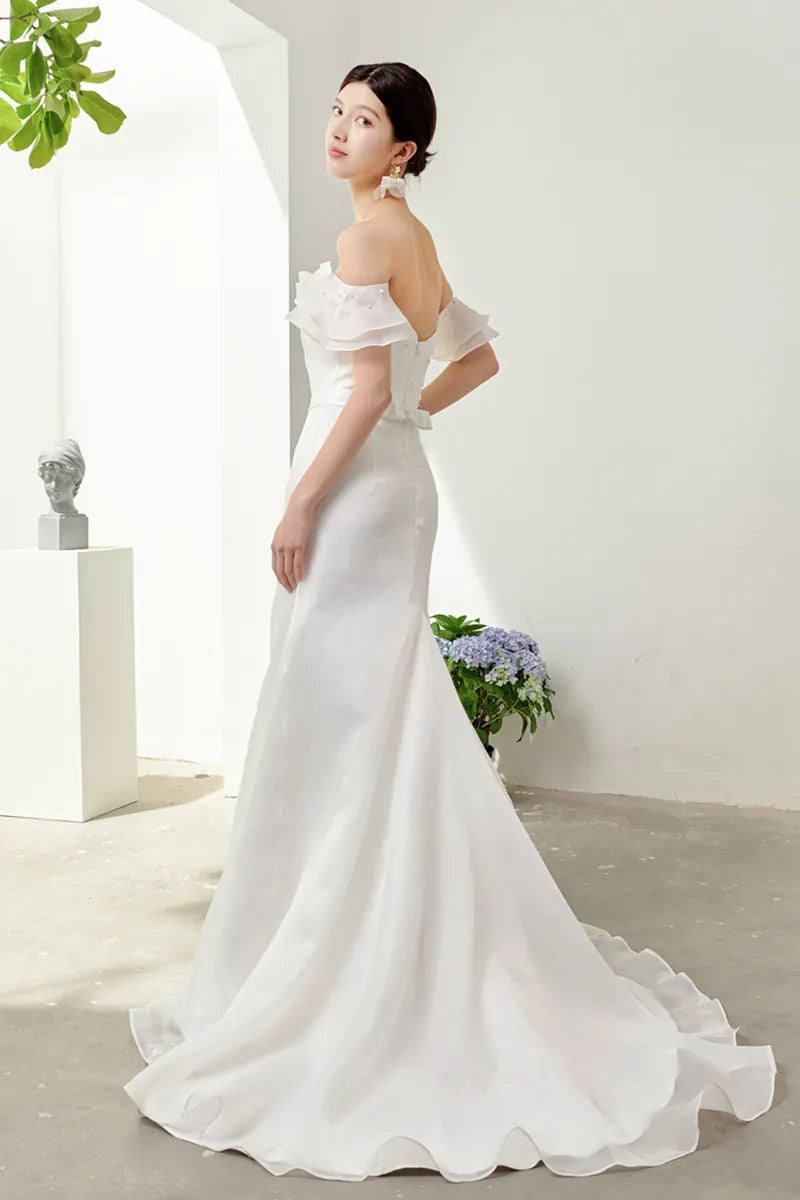 Femme élégante debout portant une robe de mariée chic et simple bohème