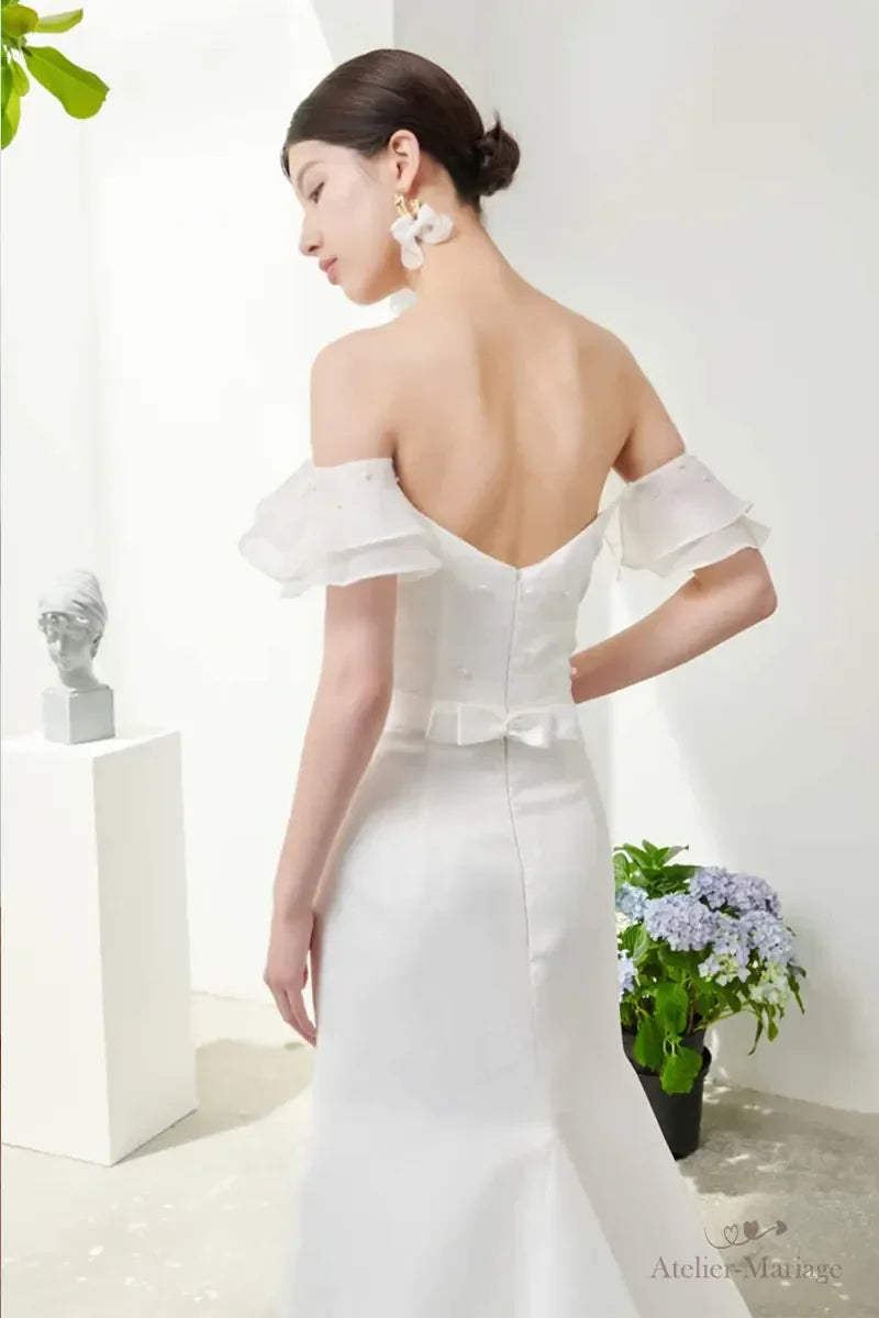 Mariée vue de dos portant une robe simple chic et bohème en organza structuré