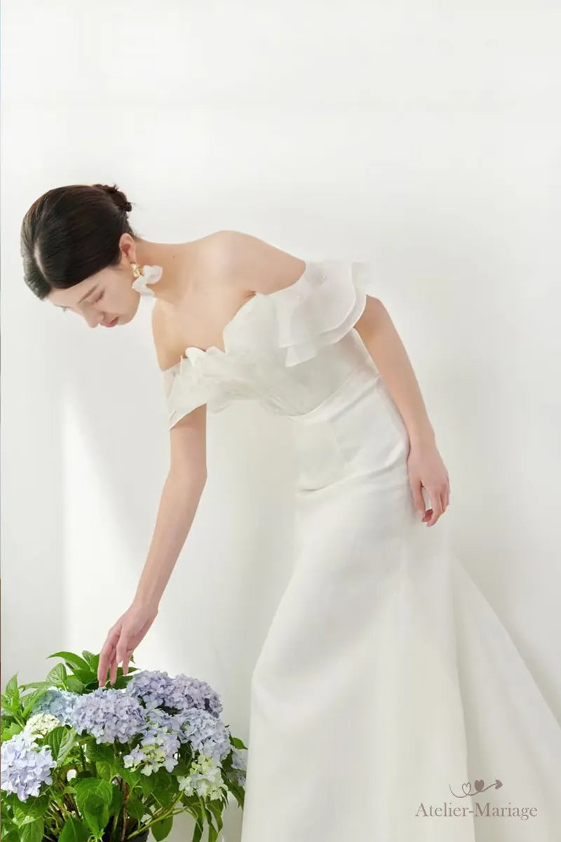 Femme élégante se penchant en robe de mariée blanche chic