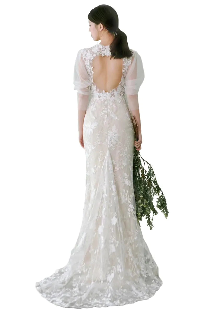 Vue du dos d’une belle femme en robe de mariée longue à manches bouffantes bohème chic
