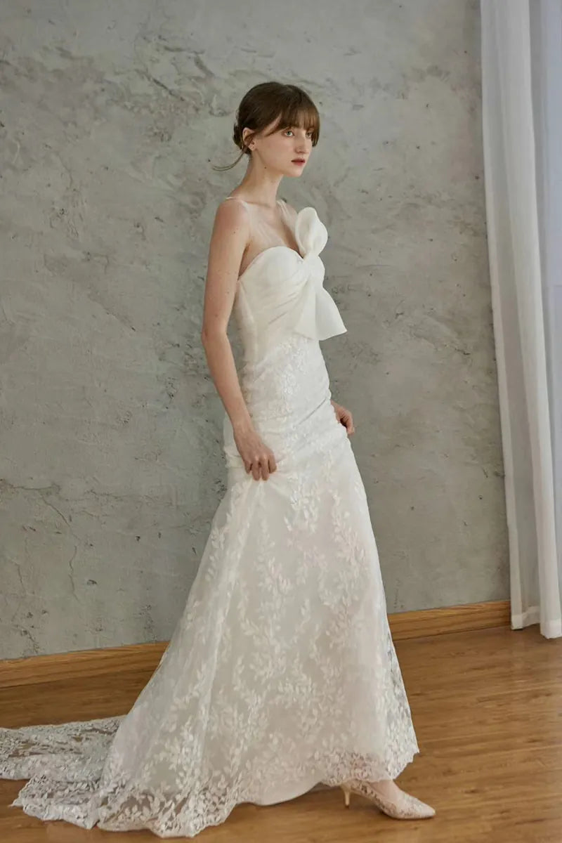 Belle femme élégante portant une robe de mariée sirène dos nu en dentelle bohème chic