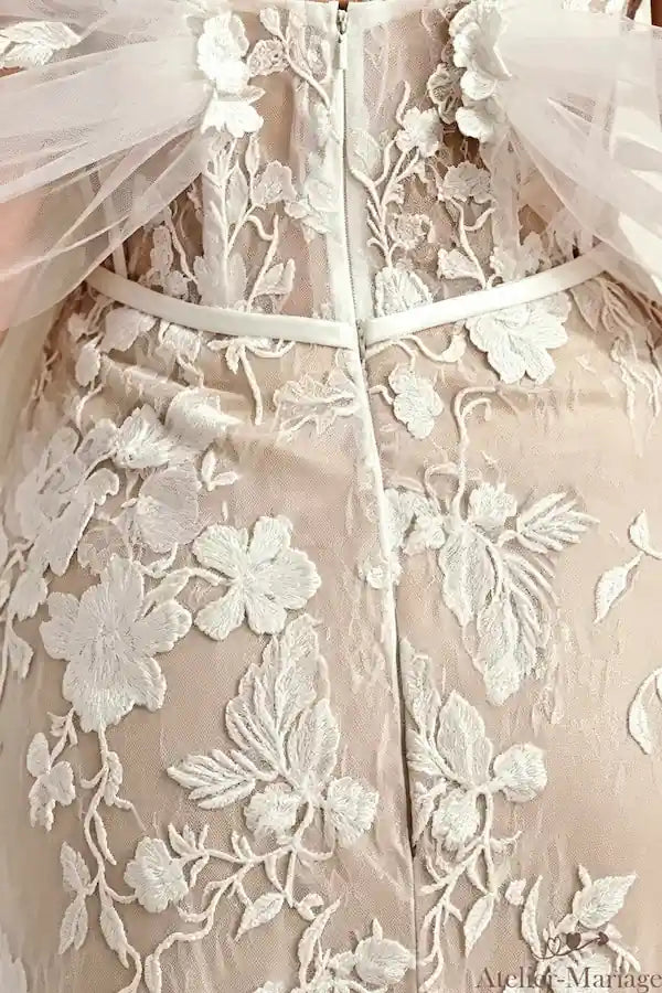 Détail de la fermeture discrète sur une robe de mariée sirène en dentelle de luxe.