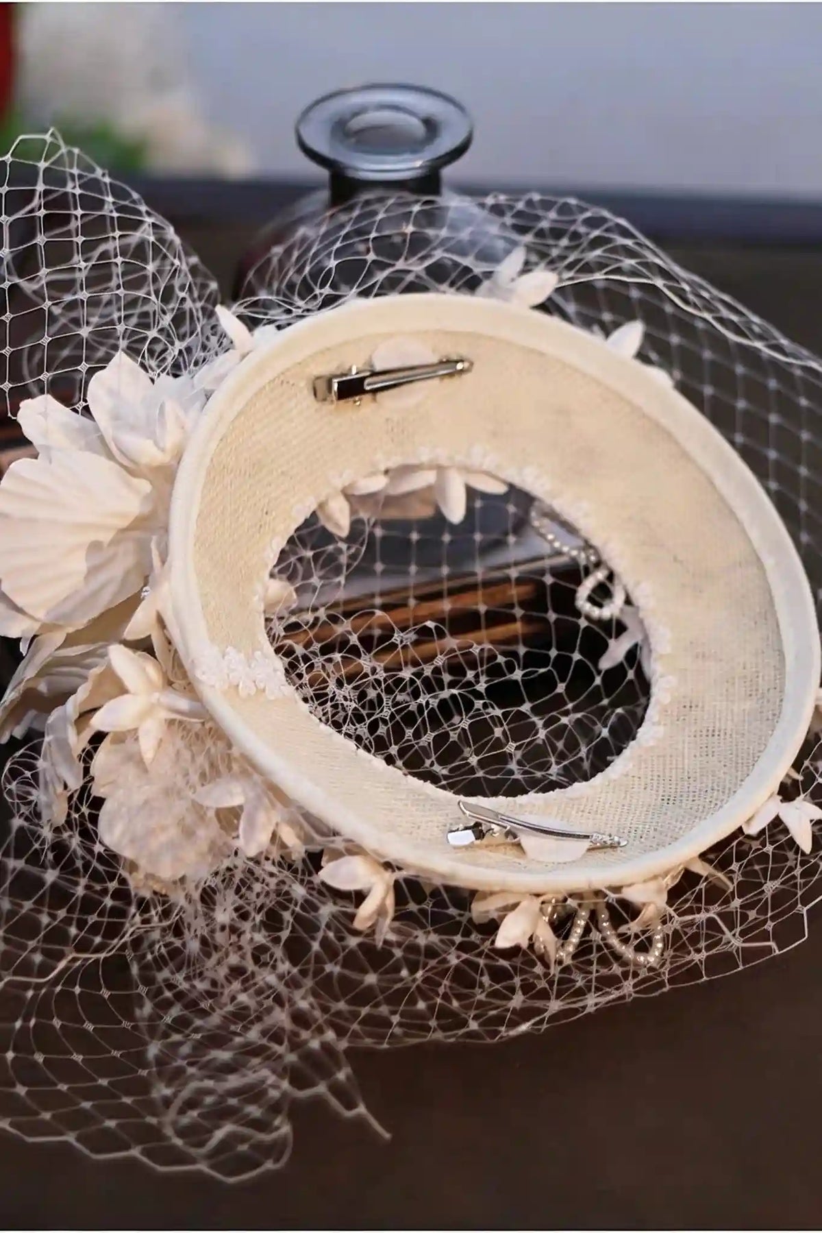 Vue intérieure du chapeau de mariée montrant les deux pinces crocodiles pour une fixation sûre.