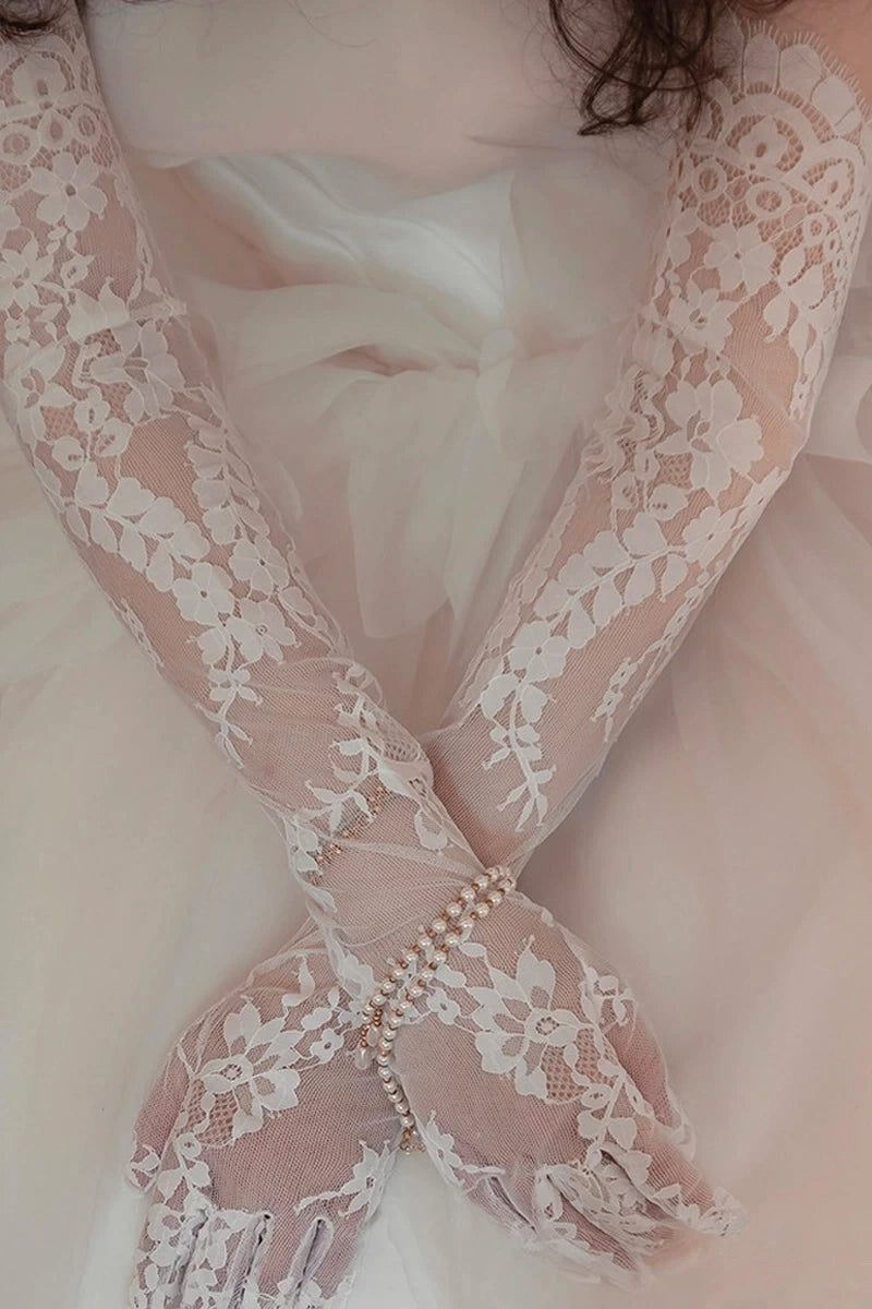 Gros plan sur des gants longs de mariée en dentelle fine ivoire faisant office de manches amovibles