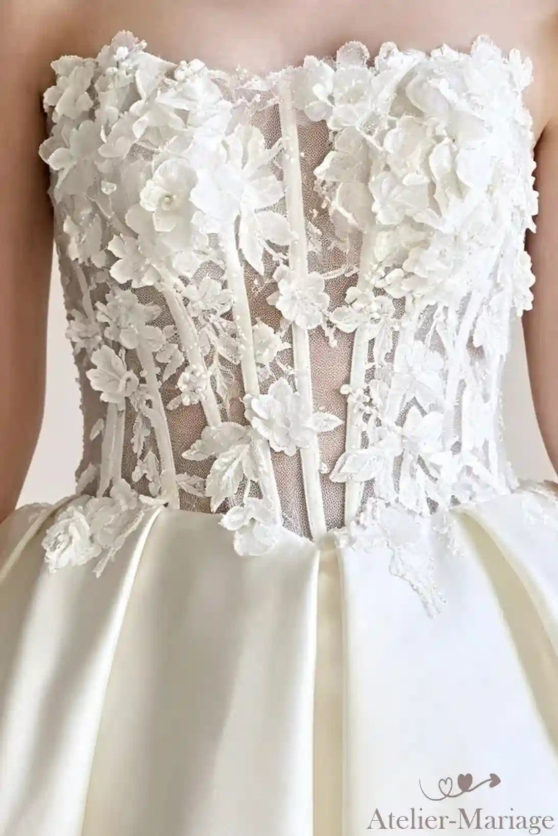 Vue rapprochée du travail des fleurs 3D créant un jardin poétique sur le bustier.