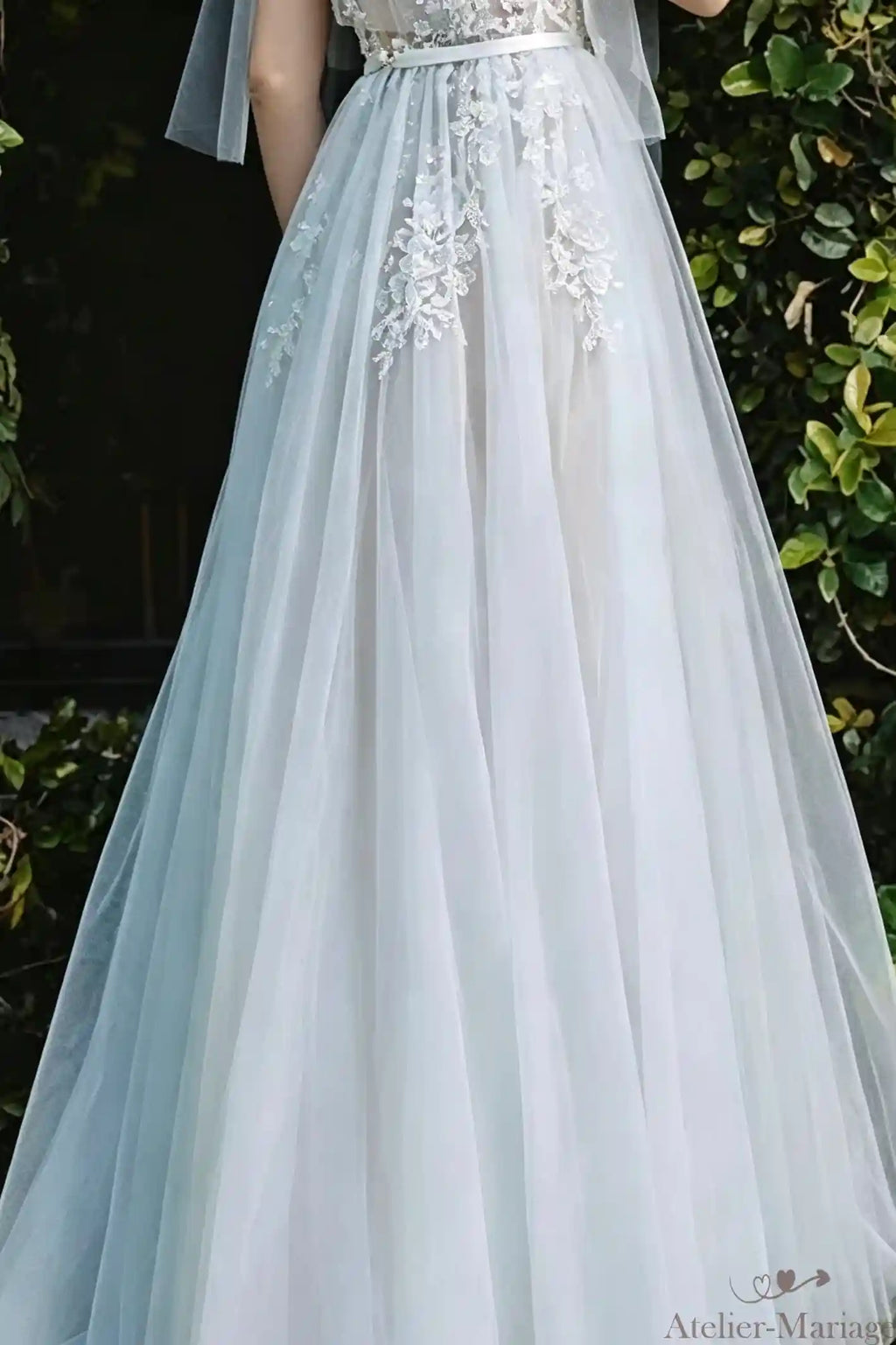 Zoom sur les appliques de dentelle parsemées sur la jupe en tulle fluide.