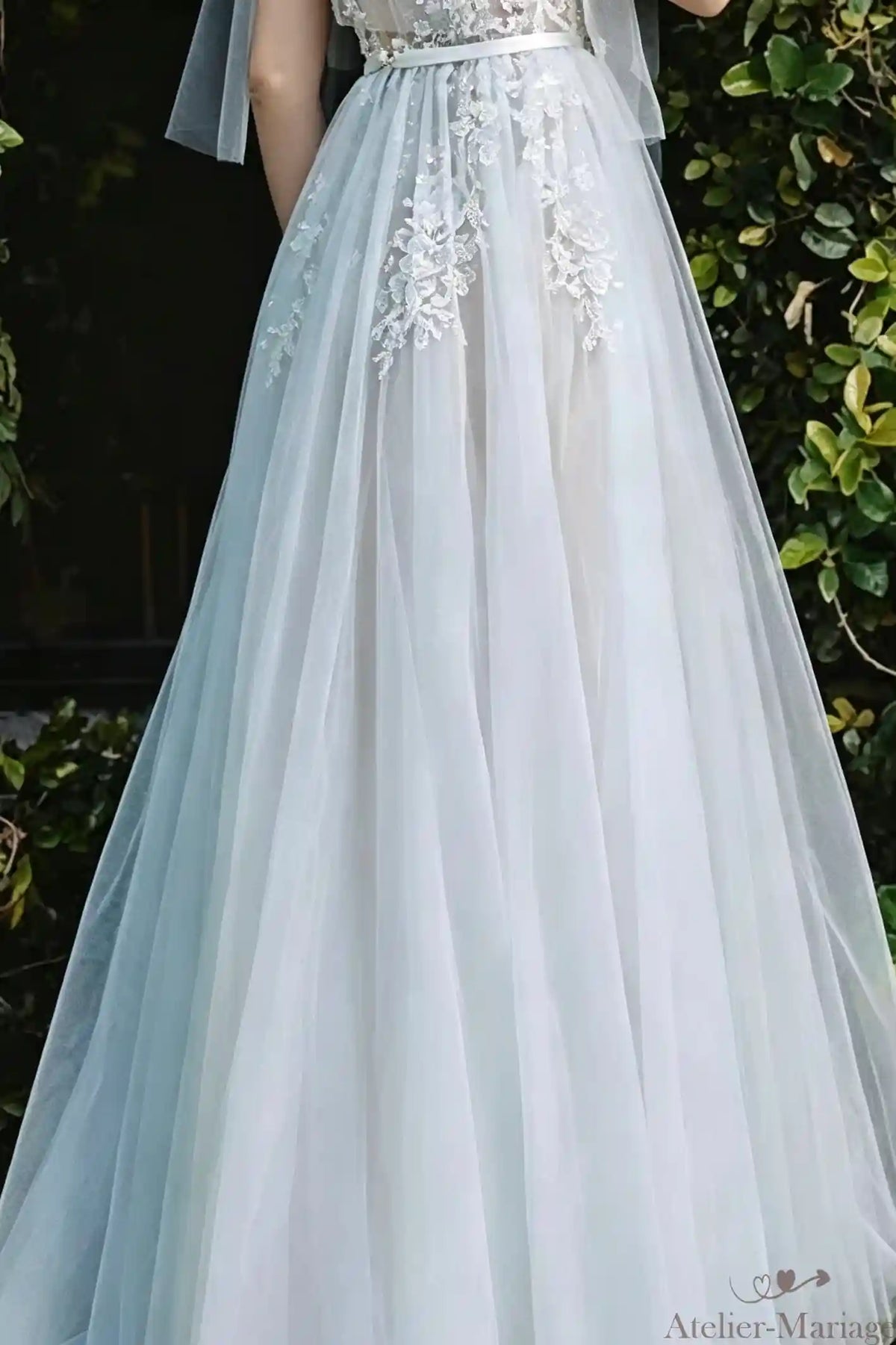Zoom sur les appliques de dentelle parsemées sur la jupe en tulle fluide.