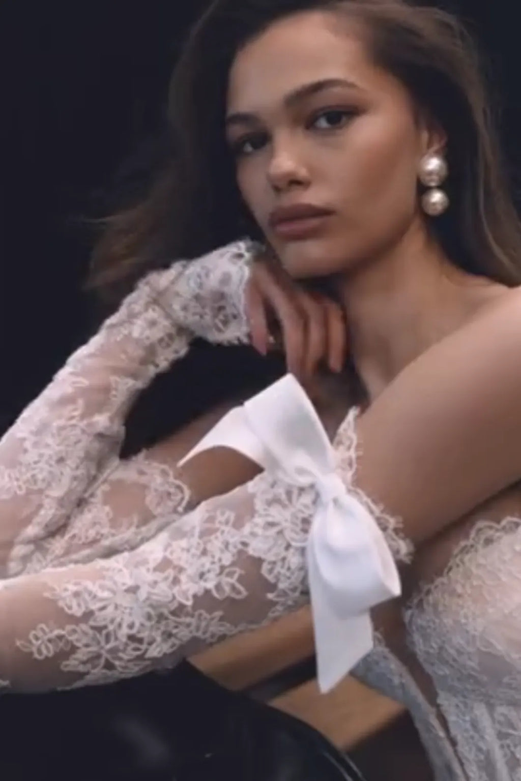 Mariée levant les bras montrant la souplesse de la dentelle sans structure rigide.