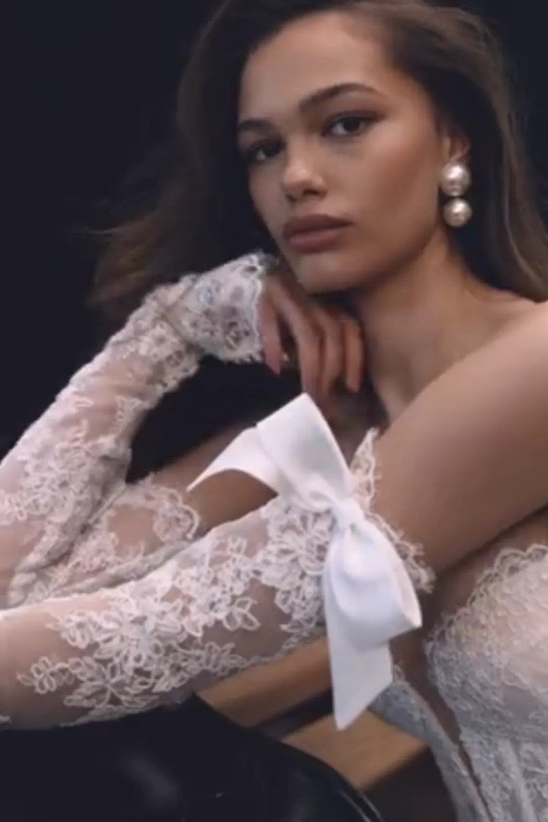 Mariée levant les bras montrant la souplesse de la dentelle sans structure rigide.