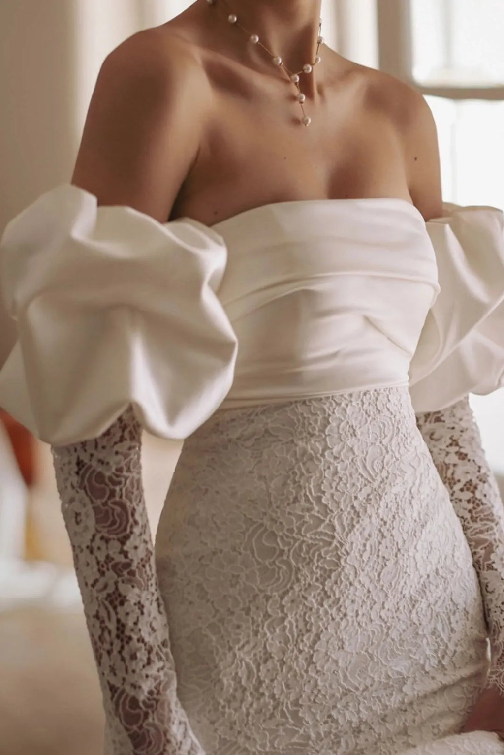 Effet col Bardot créé par des manches en satin fluide posées sur les épaules.