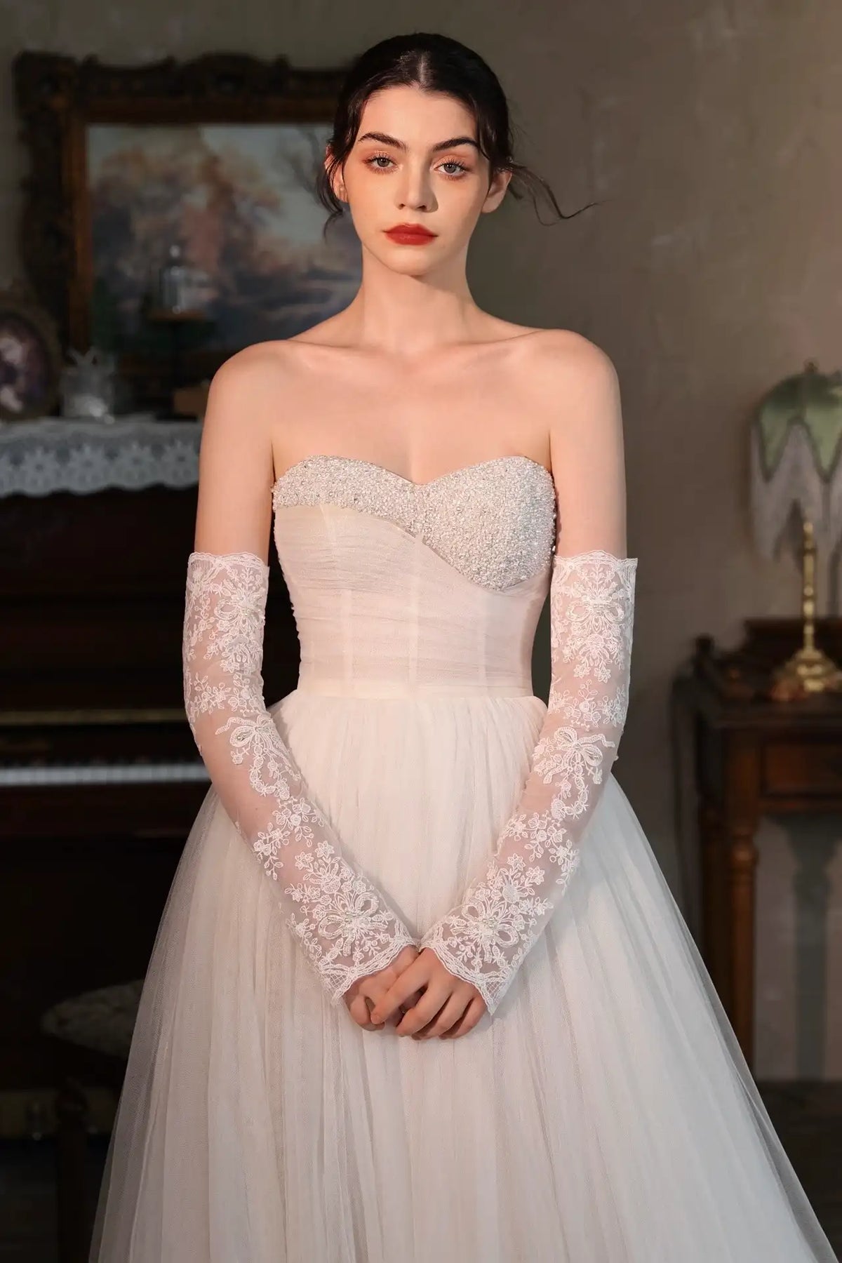 Mariée portant des manches amovibles en dentelle perlée avec attache ruban pour un look bohème chic.