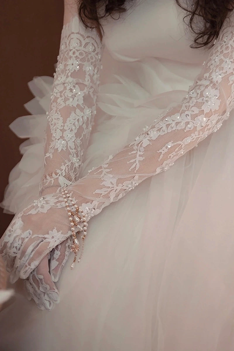 Manches amovibles perlées et gants de mariée en dentelle ivoire haute couture.