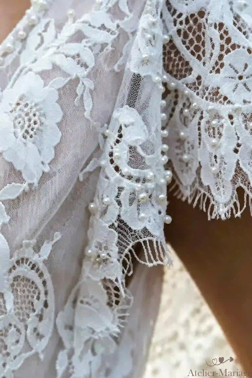 Détails des manches courtes en dentelle perlée, un travail d'artisanat traditionnel.