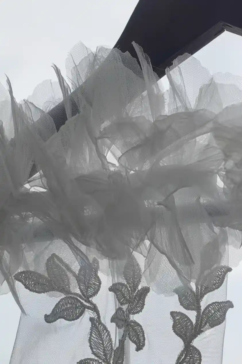 Gros plan sur la dentelle effet tatouage et les fleurs 3D délicates pour manches amovibles de mariée.