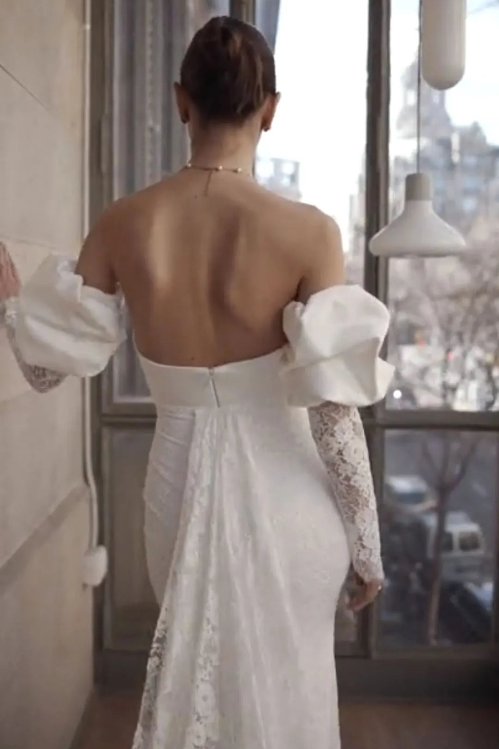 Mouvement fluide du tissu satin et dentelle lors des gestes de la mariée.