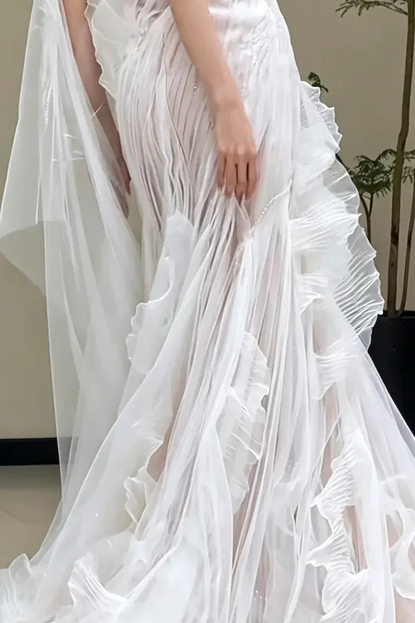 Détail du mouvement et de la fluidité des volants en tulle de soie sur une jupe de mariée spectaculaire.