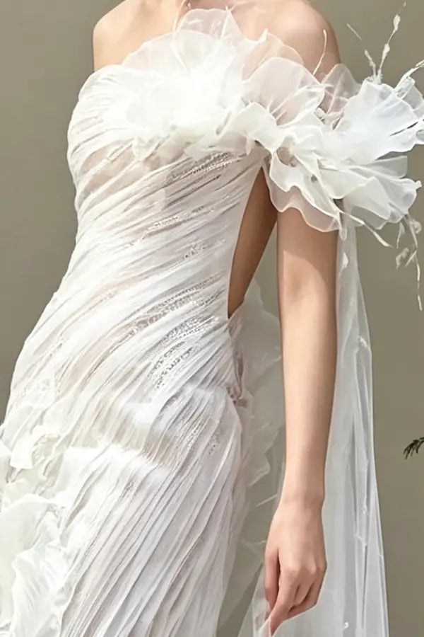 Travail du tulle plissé en diagonale et cascade de volants aériens sur une robe de mariée haute couture.