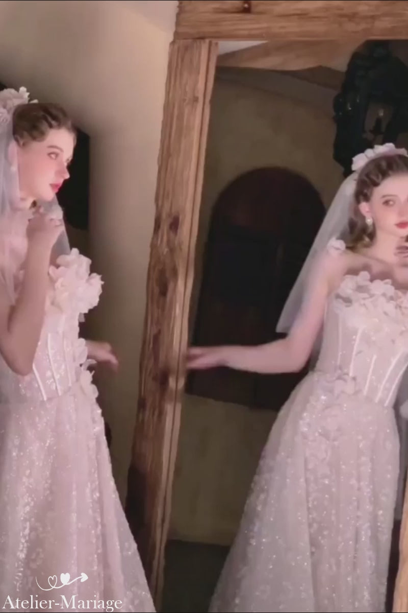 Vidéo d'une mariée s'admirant devant un miroir de face et de profil, portant une luxueuse robe princesse à paillettes et fleurs 3D.