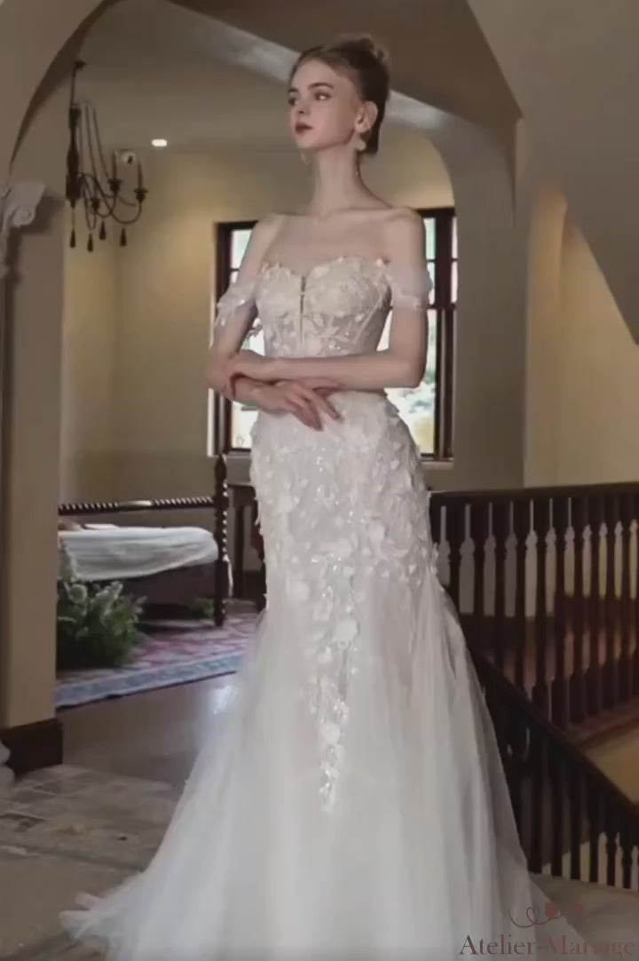 Vidéo de présentation d'une mannequin portant la robe de mariée bohème col bateau. Montre le mouvement de la dentelle et du tulle sous différents angles. Regardez la vidéo pour voir la robe en action.