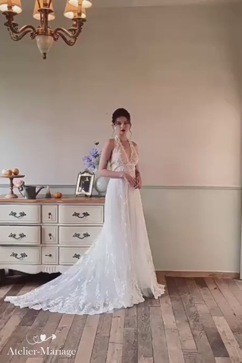 Zoom sur la dentelle fine et le décolleté dos nu plongeant d'une robe de mariée bohème sexy.