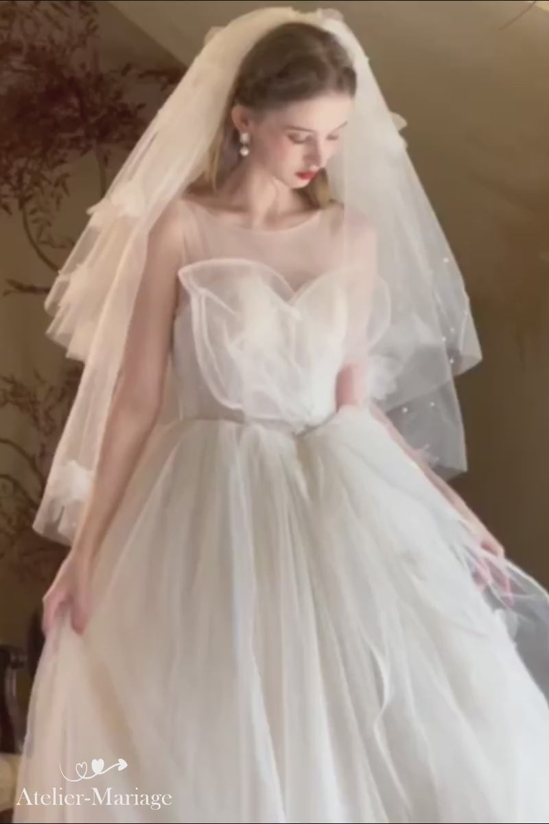 Mannequin tournant avec une robe de mariée princesse en tulle multicouches, montrant la légèreté et les fleurs 3D.