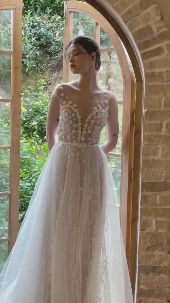 Vidéo haute définition montrant les détails de fleurs 3D et le mouvement du tulle sur une robe de mariée bohème.