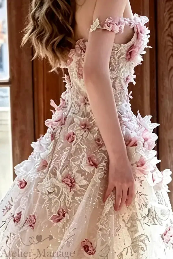 Zoom sur la texture des pétales en organza et les reflets des sequins sur la robe de mariée blush, focus sur la qualité des matières.