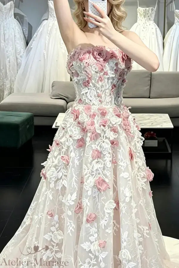 Vue complète en miroir de la robe de mariée rose blush, illustrant le volume du tulle et la cascade de fleurs en relief en conditions réelles.