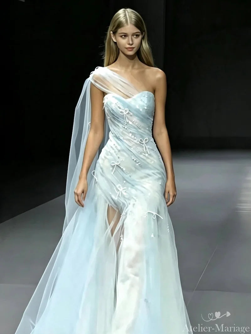 Robe de mariée bleu brume asymétrique magnifiant une peau bronzée et mate