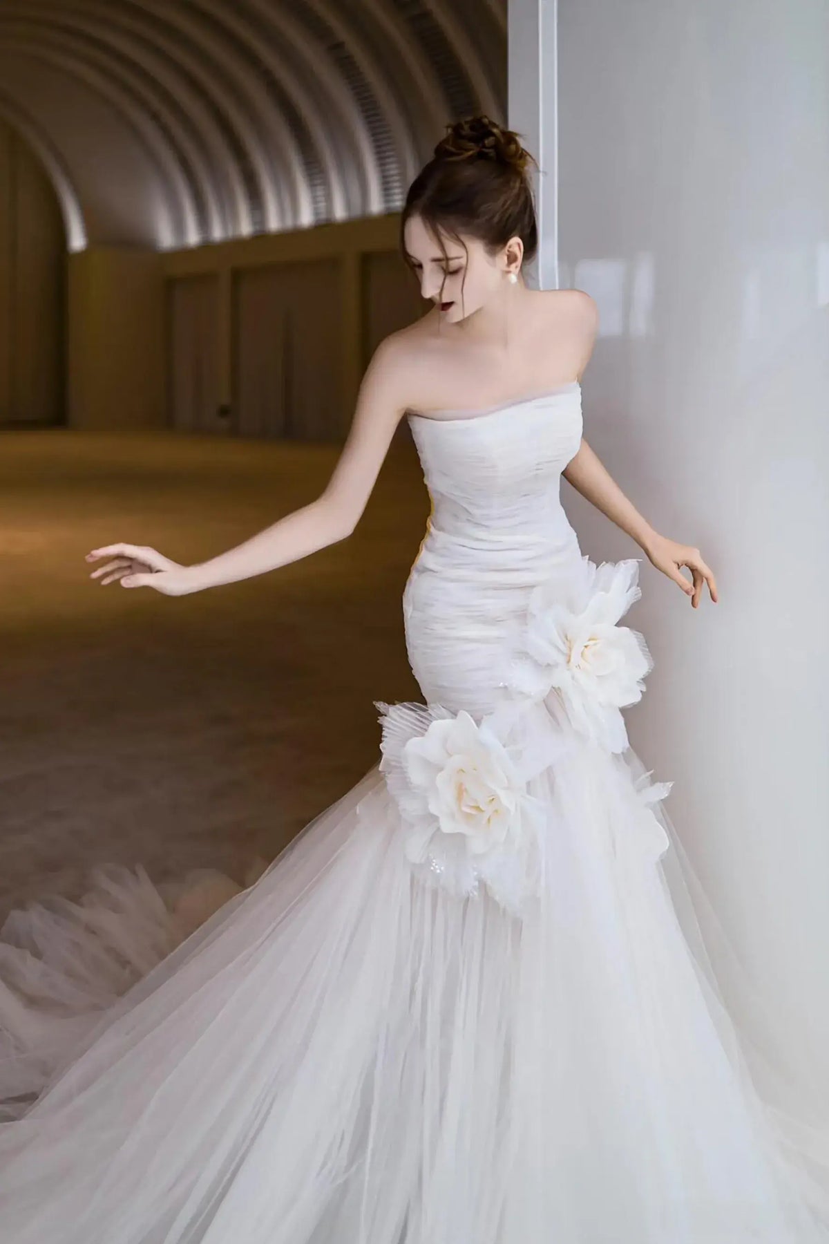 Robe de mariée à fleurs volumineuses en tulle posées sur la taille pour une silhouette sirène.