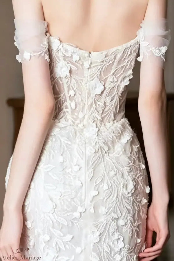 Vue arrière de la robe de mariée : dos en tulle transparent avec fermeture éclair invisible, accentué par les mêmes motifs de dentelle et de fleurs 3D que le devant. Admirez la beauté sous tous les angles.