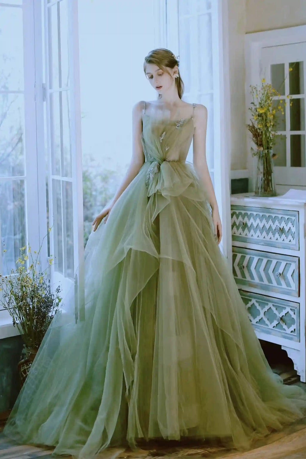 Robe de mariée bohème de couleur vert sauge avec une jupe très volumineuse en couches de tulle.
