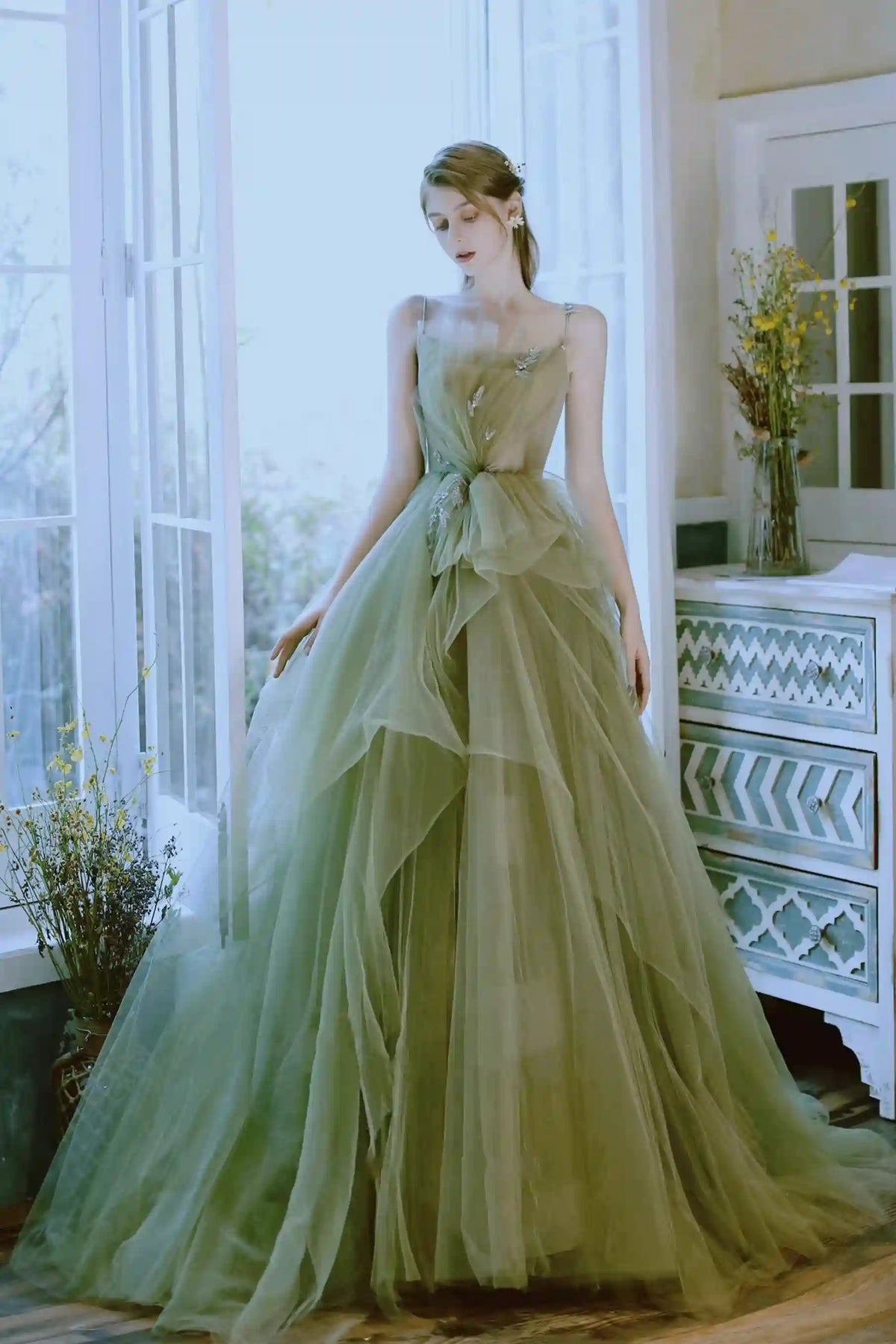Robe de mariée bohème de couleur vert sauge avec une jupe très volumineuse en couches de tulle.